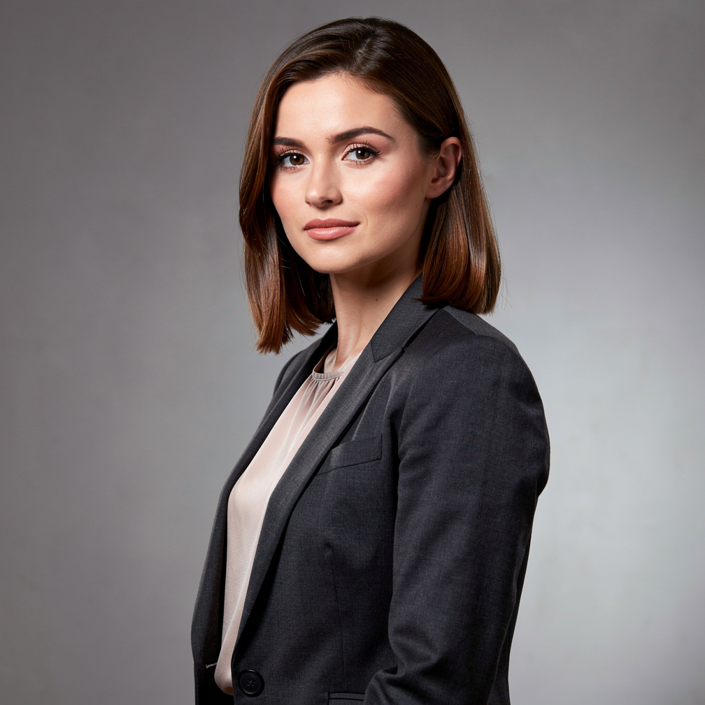 British woman in her late twenties smiling in a news studio